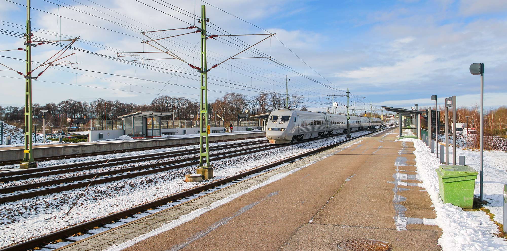 Ett SJ X2-tåg passerar stationen i Falkenberg 2021