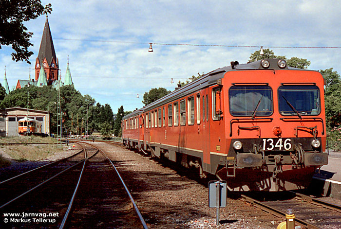 Y1 1346 och 1336 har just ankommit Västervik från Linköping. I bakgrunden S:t Petri kyrka samt smalspårsrälsbussen YP 888. Foto i juli 1989, Markus Tellerup.