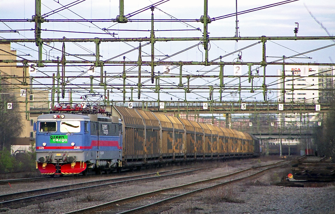 Ett långt godståg lämnar Värtan i april 2003. Viadukten i bakgrunden är tunnelbanans linje mot Ropsten. Foto Markus Tellerup.