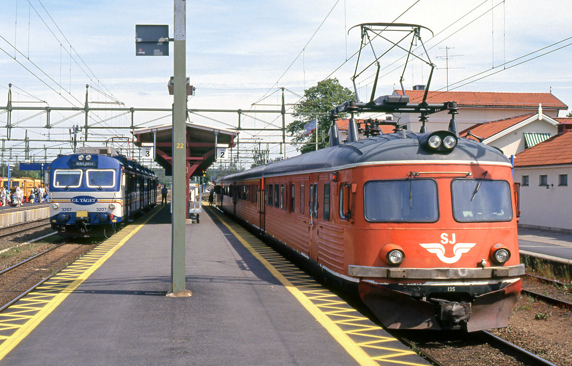 Järnvägsknuten Herrljunga den 1 juli 1993. Ett X10-tåg mot Uddevalla och ett X9-tåg mot Borås inväntar avgång. På plattformen längst till vänster väntar resenärer på X2000-tåget till Stockholm. Foto Markus Tellerup.