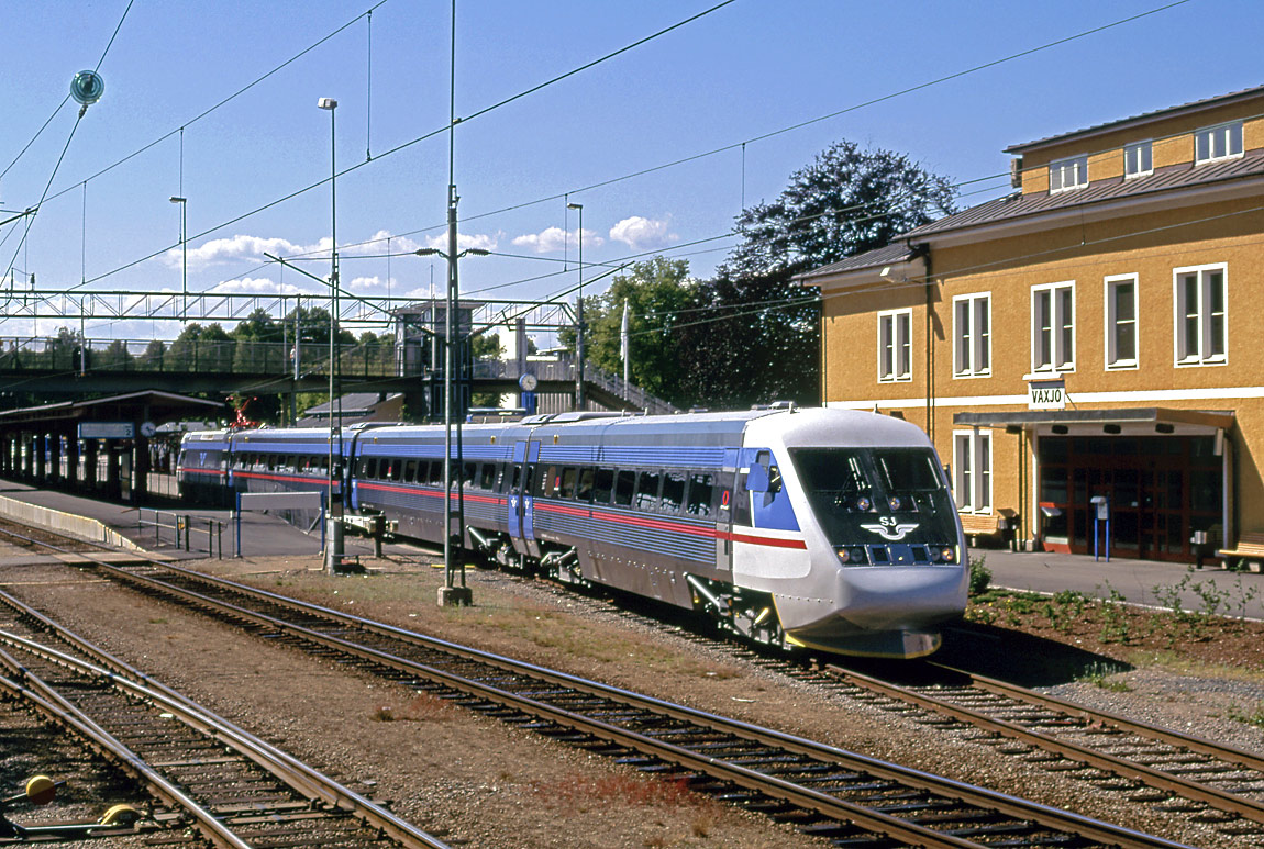 Ett kort X2-tåg (som på den tiden benämndes X2-2) lämnar Växjö station på väg mot Kalmar i juli 1994. Ett nytt stationshus och resecentrum öppnades i Växjö 2002. Foto Markus Tellerup.