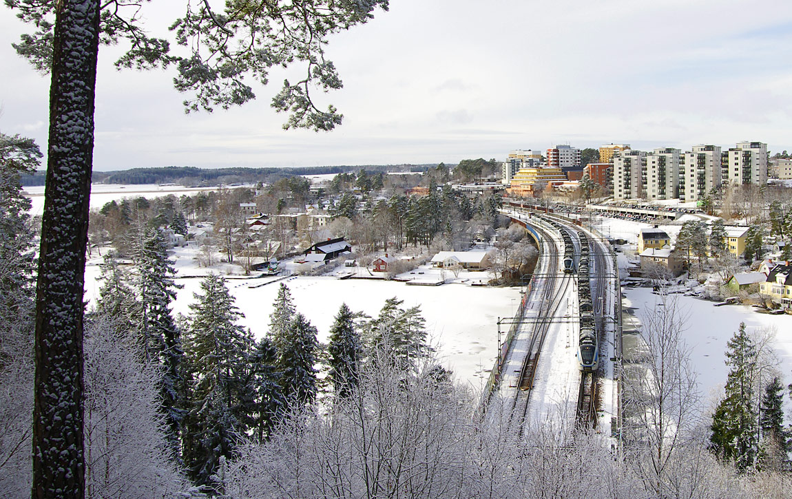 Ett pendeltåg mot Västerhaninge på väg in i Svartvikstunneln strax efter avgång från Kungsängen. I bakgrunden ett norrgående tåg. Foto i februari 2017, Markus Tellerup.