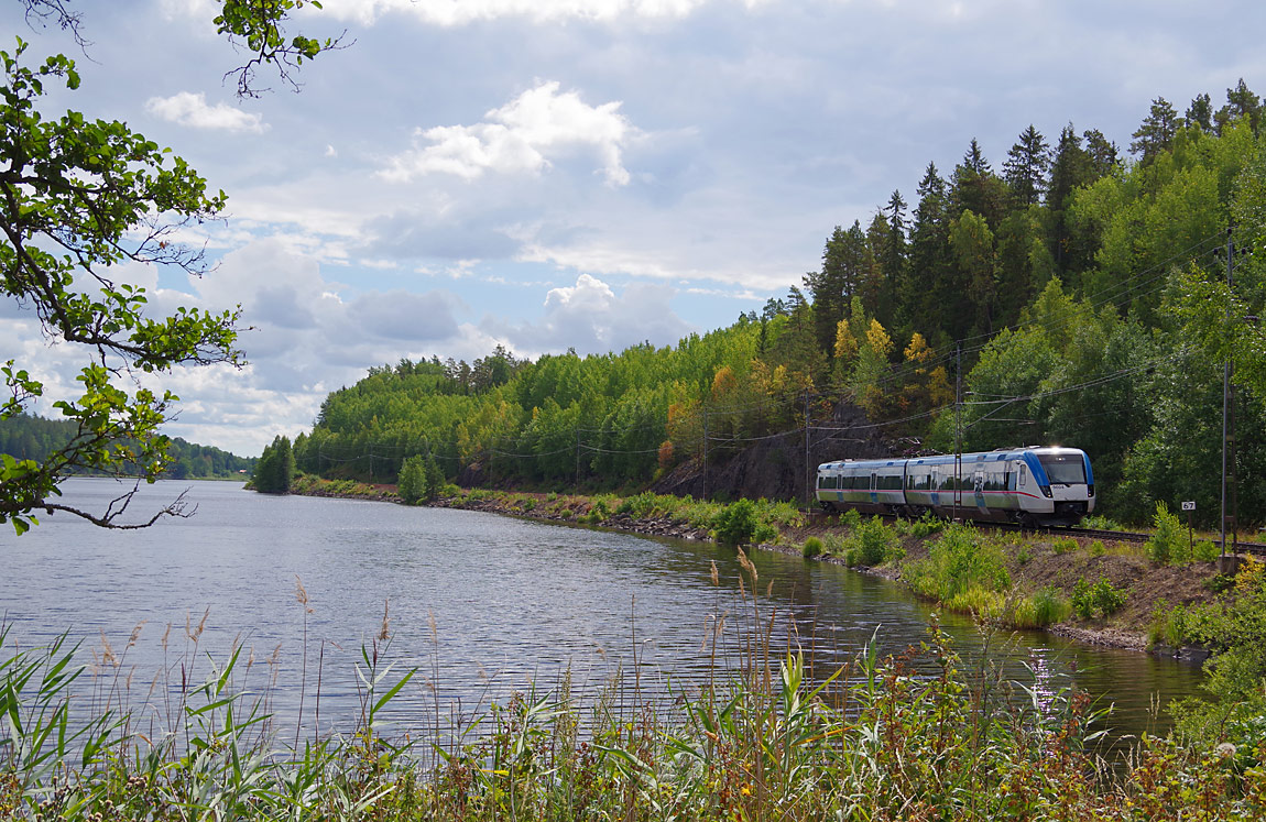 Ett tåg Linköping-Sala bestående av X50 9004 rullar norrut längs Mellösasjön. Foto i juli 2017, Markus Tellerup.
