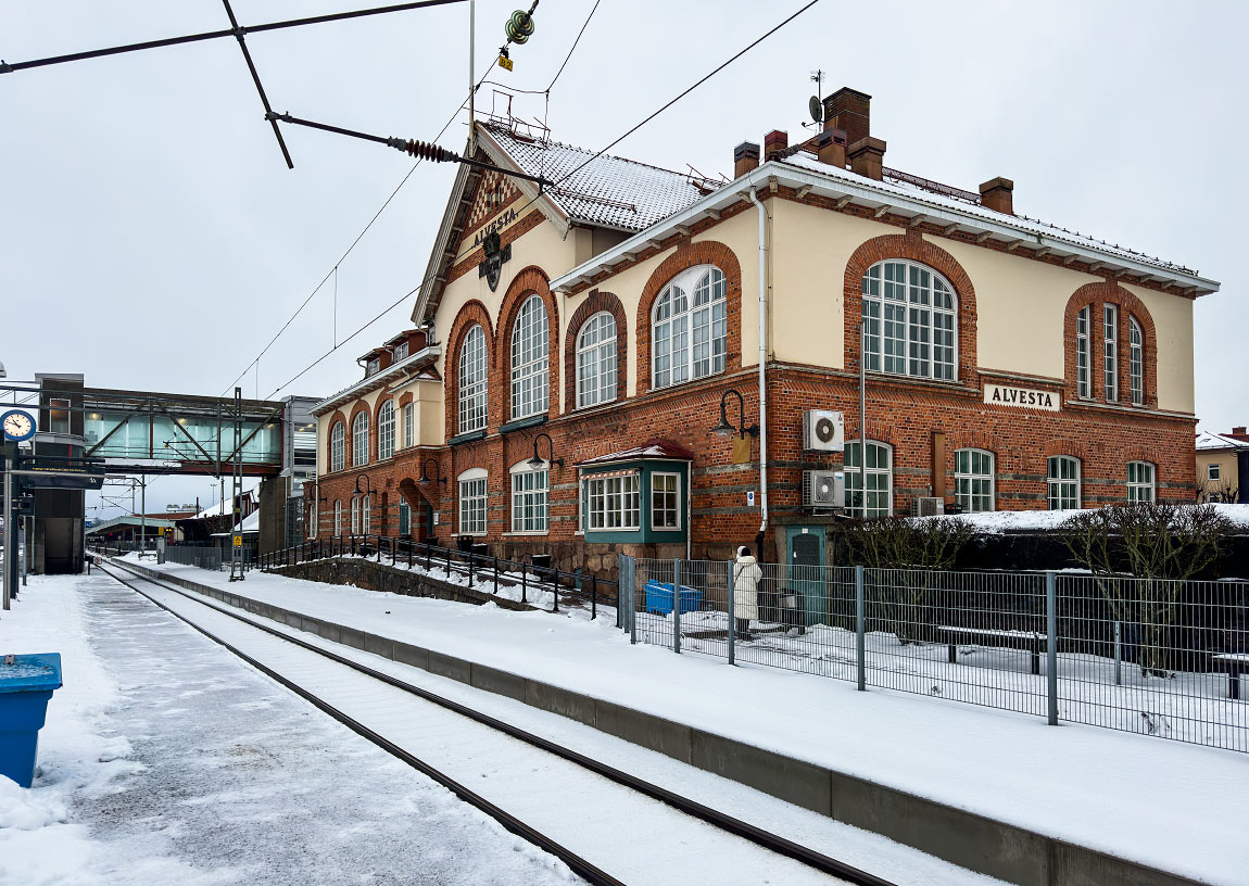 Alvesta fick ett nytt fint stationshus ritat av Folke Zettervall år 1909. Några år tidigare hade Borås-Alvesta Järnväg öppnats vilket gjorde Alvesta till en betydande järnvägsknut. Huset var unikt genom att ha väntsalen på andra våningen och en gångbro över spåren. Gångbron revs 1989 men en ny uppfördes 2012. Foto 2023, Frederik Tellerup.