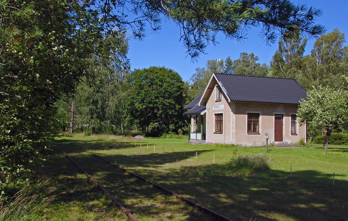 Det före detta stationshuset i Midskog med det nuvarande dressinspåret i förgrunden. På huset anges avståndet till Göteborg (213 km) - banans utgångspunkt en gång i tiden. Foto 2007, Markus Tellerup.