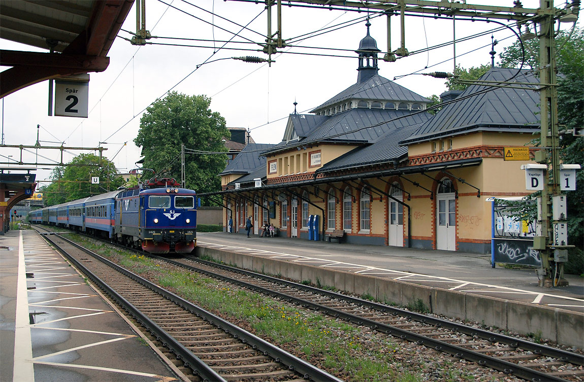 Ett InterCity-tåg Stockholm-Malmö passerar Flen. Stationshuset är från 1892 och ritades av Folke Zettervall. Det ursprungliga trähuset flyttades till Skebokvarn. Foto 2007, Markus Tellerup.