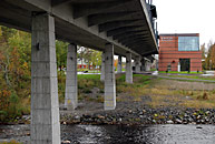 Bild: Hörnån brusar fram under Botniabanans hållplats i Hörnefors med stationshuset i bakgrunden. Foto hösten 2010.