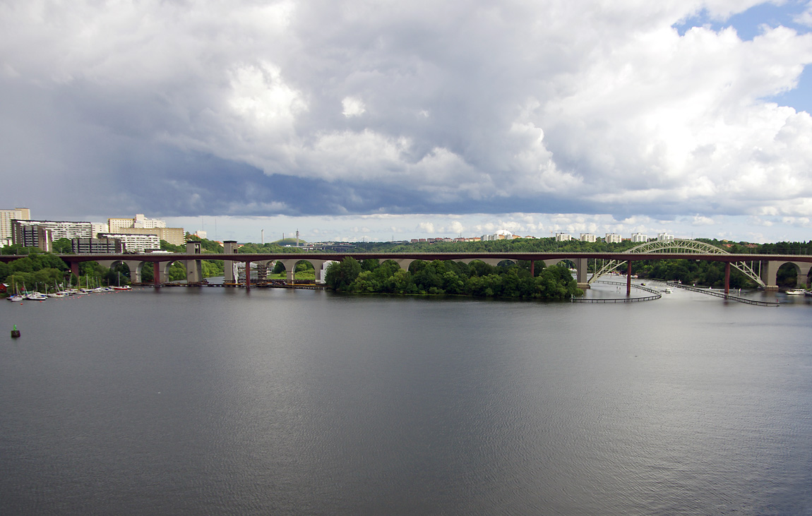 Att anlända med tåg till Stockholm söderifrån är ett bra sätt att uppleva den vackra huvudstadens många öar och vatten. Vy från Liljeholmen mot de båda Årstabroarna den 31 juli 2012. Foto Markus Tellerup.