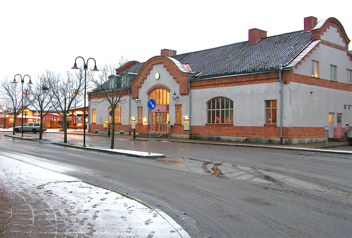 Det nuvarande stationshuset i Sandviken byggdes 1909 och ersatte då det tidigare som redan hunnit bli nästan femtio år gammalt. Tåg i Bergslagens Reginatåg gör uppehåll i bakgrunden intill bussterminalen som kom till 2004 då stationen döptes om till resecentrum. Foto i december 2013, Markus Tellerup.