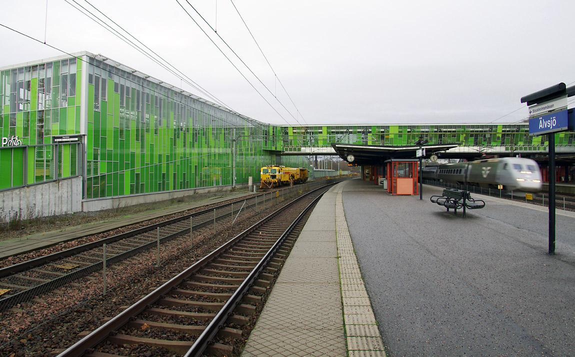 Älvsjö station präglas sedan 2012 av ett nytt resecentrum med bl.a. cykelparkeringshus och gångbro i grönt glas. Foto 2014, Markus Tellerup.