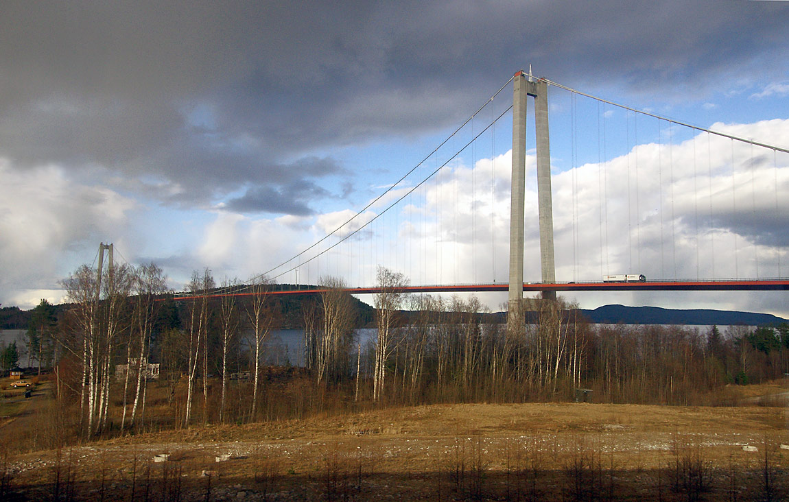Utsikt från tågfönstret över Ångermanälven och Högakustenbron. Bron som leder E4:an över älven sedan 1997 är även känd under namnet Vedabron och ståtar med Sveriges längsta brospann på över 1200 meter. Foto 2015, Markus Tellerup.