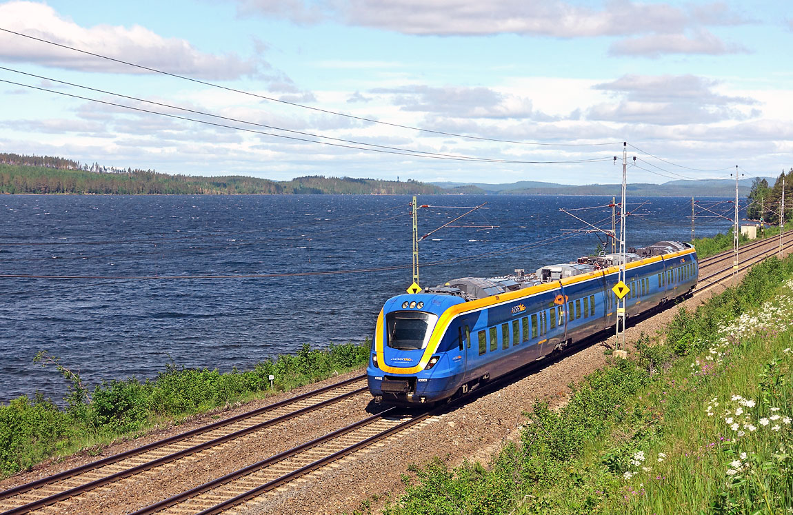 Norrtågs X62-motorvagn 003 på väg från Duved till Sundsvall vid Revsundssjön strax söder om Bräcke. Foto i juli 2015, Markus Tellerup.