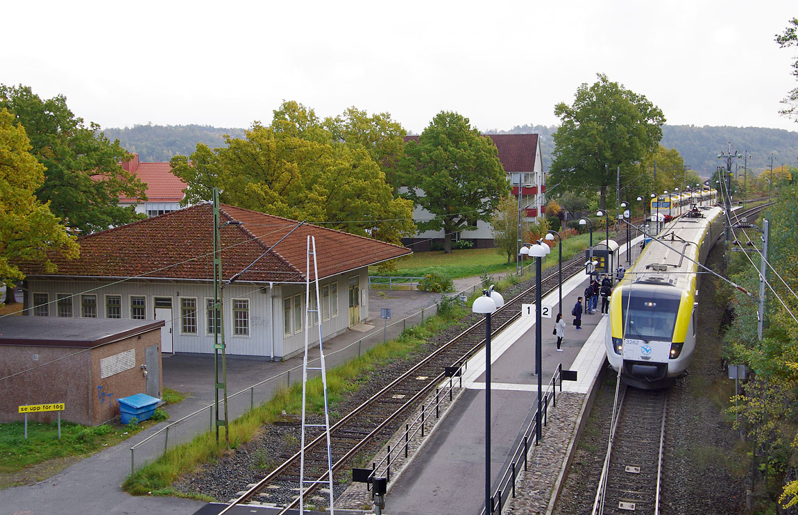 Tågmöte i Huskvarna i oktober 2015. Det nedgångna stationshuset från 1944 hade vid tidpunkten precis räddats från rivning. Foto Markus Tellerup.