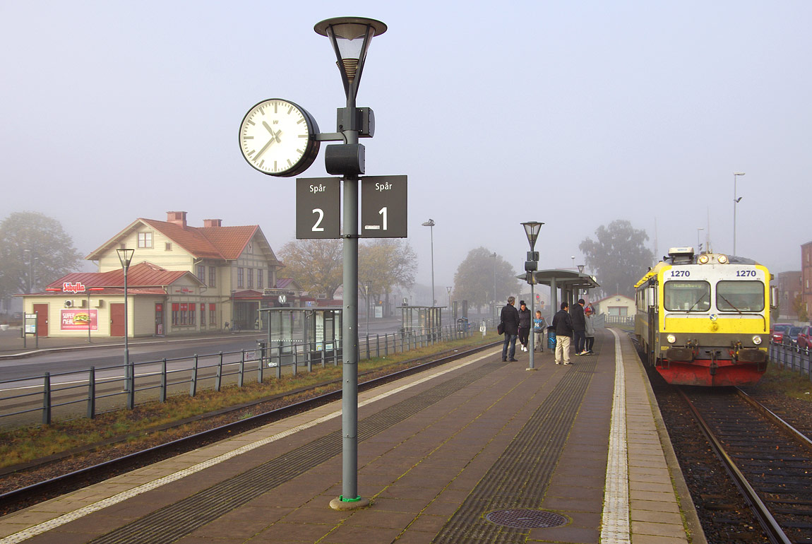 En Y1-motorvagn mot Hallsberg inväntar avgång i Lidköping en söndag 2015. Spåren ligger ett stycke från stationshuset efter en ombyggnad 2008 - jämför med bilden nedanför. Foto Markus Tellerup.