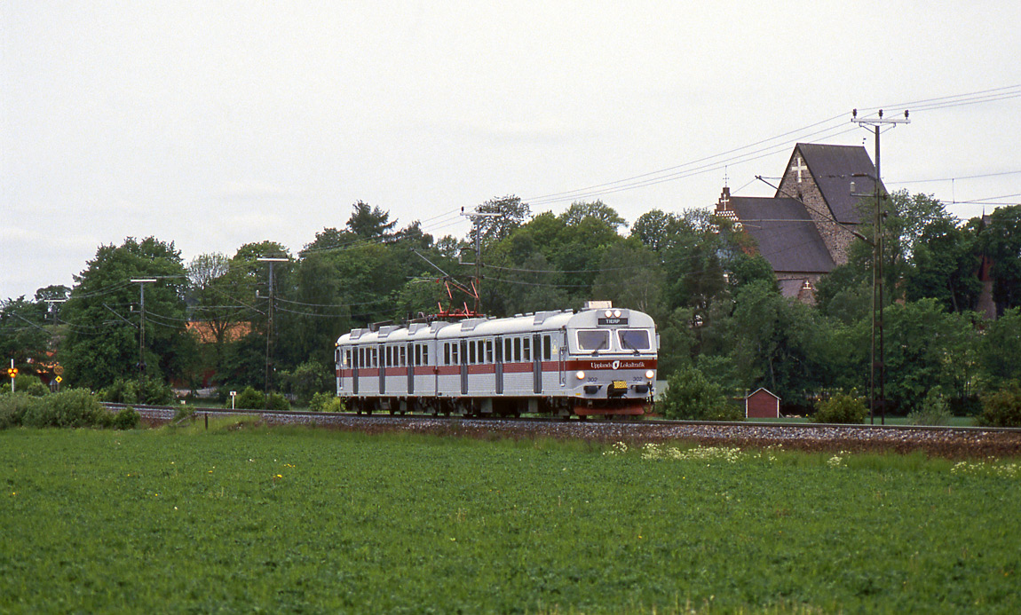 Ursprungligen användes tre X10-motorvagnar för lokaltrafiken Uppsala-Tierp (Upptåget). Här ses en av dem, 3188, passera kyrkan i Gamla Uppsala sommaren 1994. Foto Markus Tellerup.