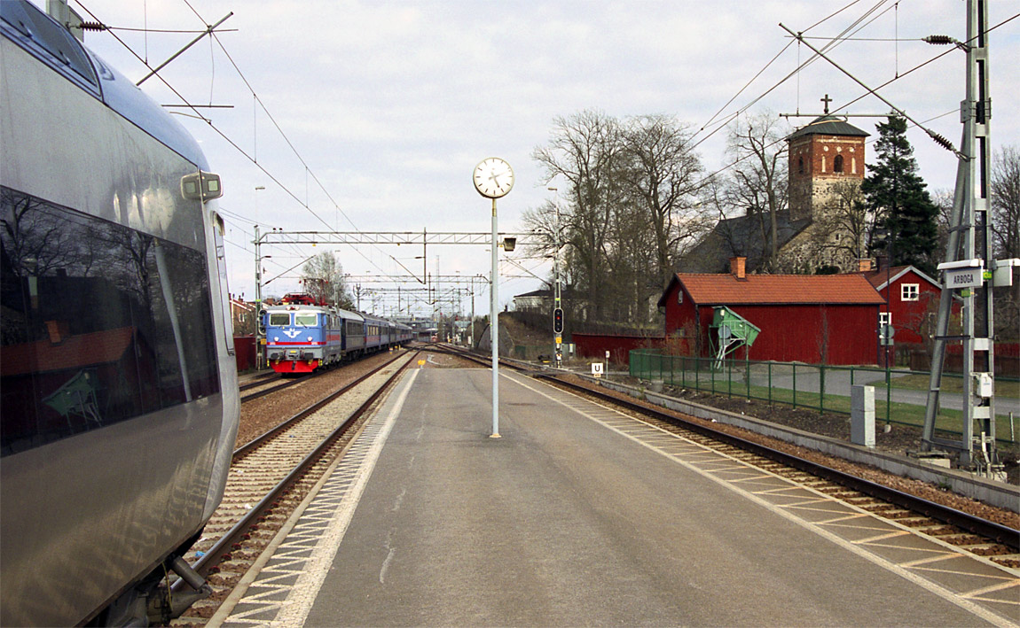 Ett tåg från Stockholm anländer till Arboga den 30 april 2003. Till vänster St Nikolai kyrka. I förgrunden en av de Reginamotorvagnar som vid tidpunkten trafikerade Mälar- och Svealandsbanorna. Foto Markus Tellerup.